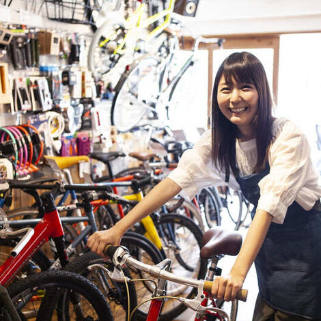 自転車を押す女性スタッフ