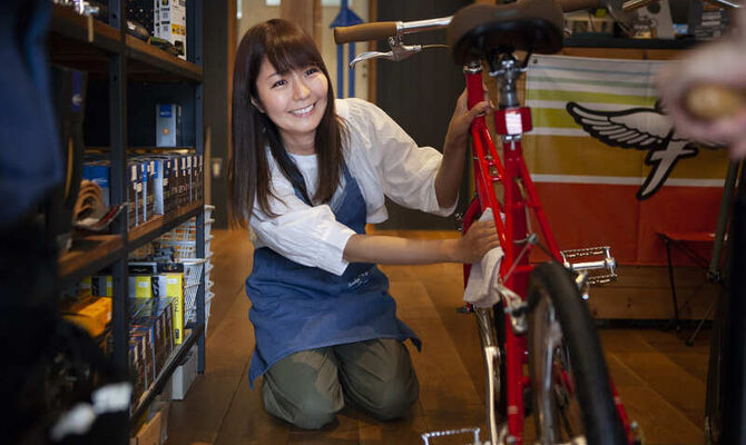 自転車を磨く女性スタッフ