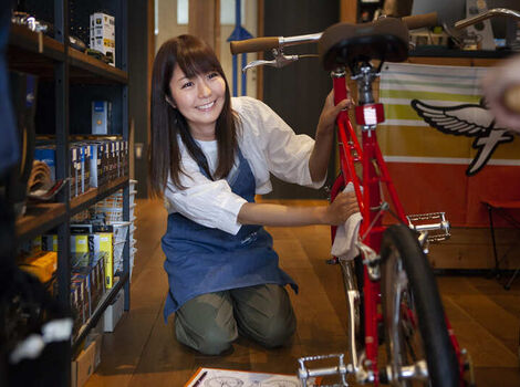 自転車を磨く女性スタッフ