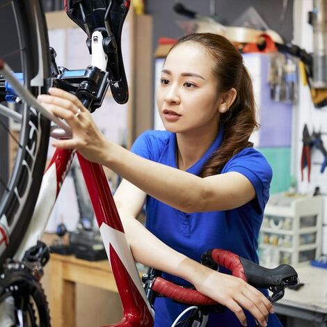 自転車を整備する女性スタッフ