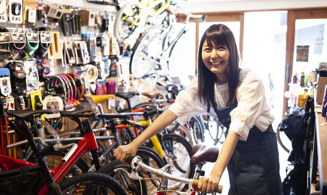 自転車を押す女性スタッフ