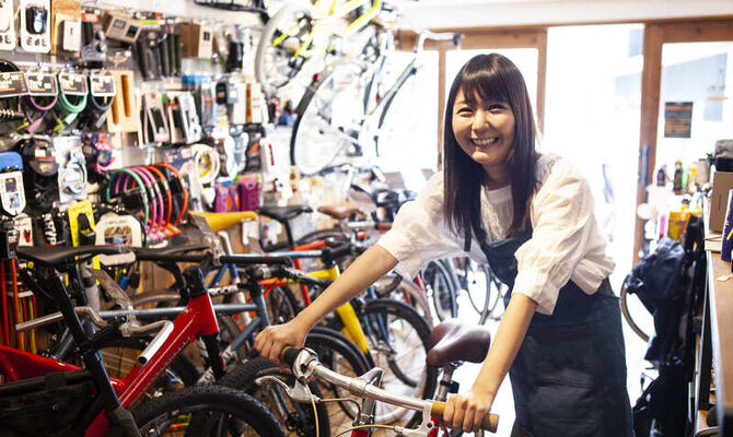 自転車を押す女性スタッフ